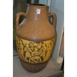 A large pottery twin handled vase decorated with musicians and figures.