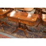 A Regency rosewood and brass inlaid foldover card table, the rectangular top with clipped corners on