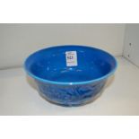 A Chinese blue glazed bowl with moulded dragon decoration.