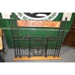 An unusual wrought iron and copper cashier's screen.