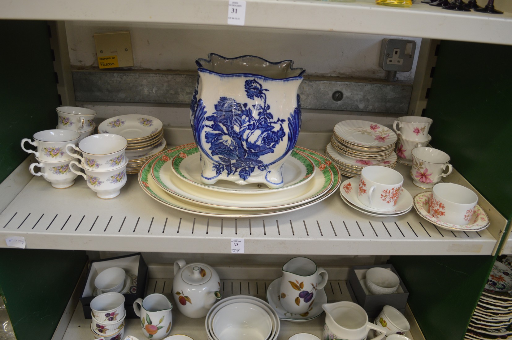 Three shelves of decorative and household china.