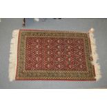 A small Persian rug, red ground with geometric decoration.