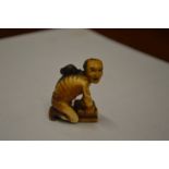 A Japanese Meiji period carved ivory small okimono of a rat catcher.