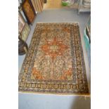 A Persian rug, beige ground with floral stylized decoration.