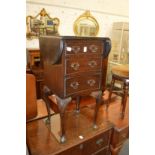 A mahogany drop flap three drawer bedside table.