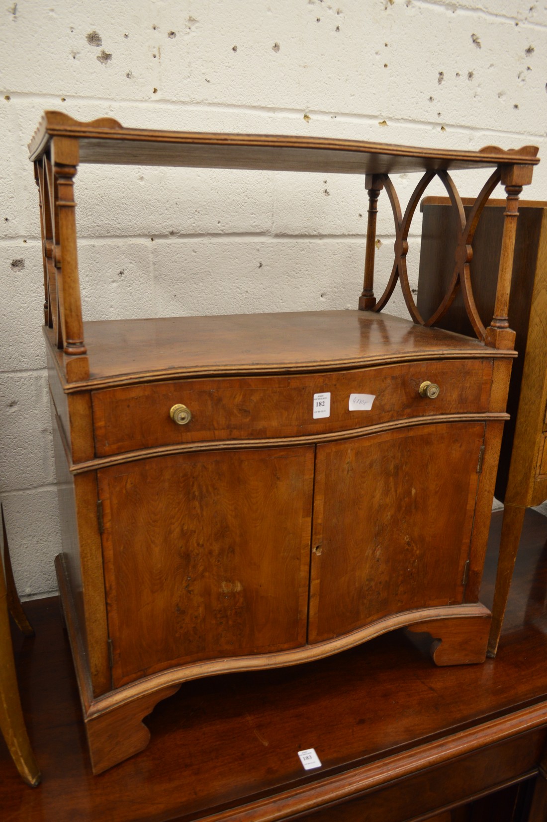 A small yew wood lamp table or side cabinet with a single drawer and a pair of doors.