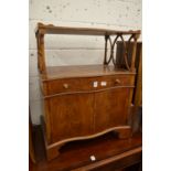 A small yew wood lamp table or side cabinet with a single drawer and a pair of doors.