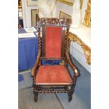 An 18th century walnut armchair with carved cresting rail, upholstered back panel and seat on barley