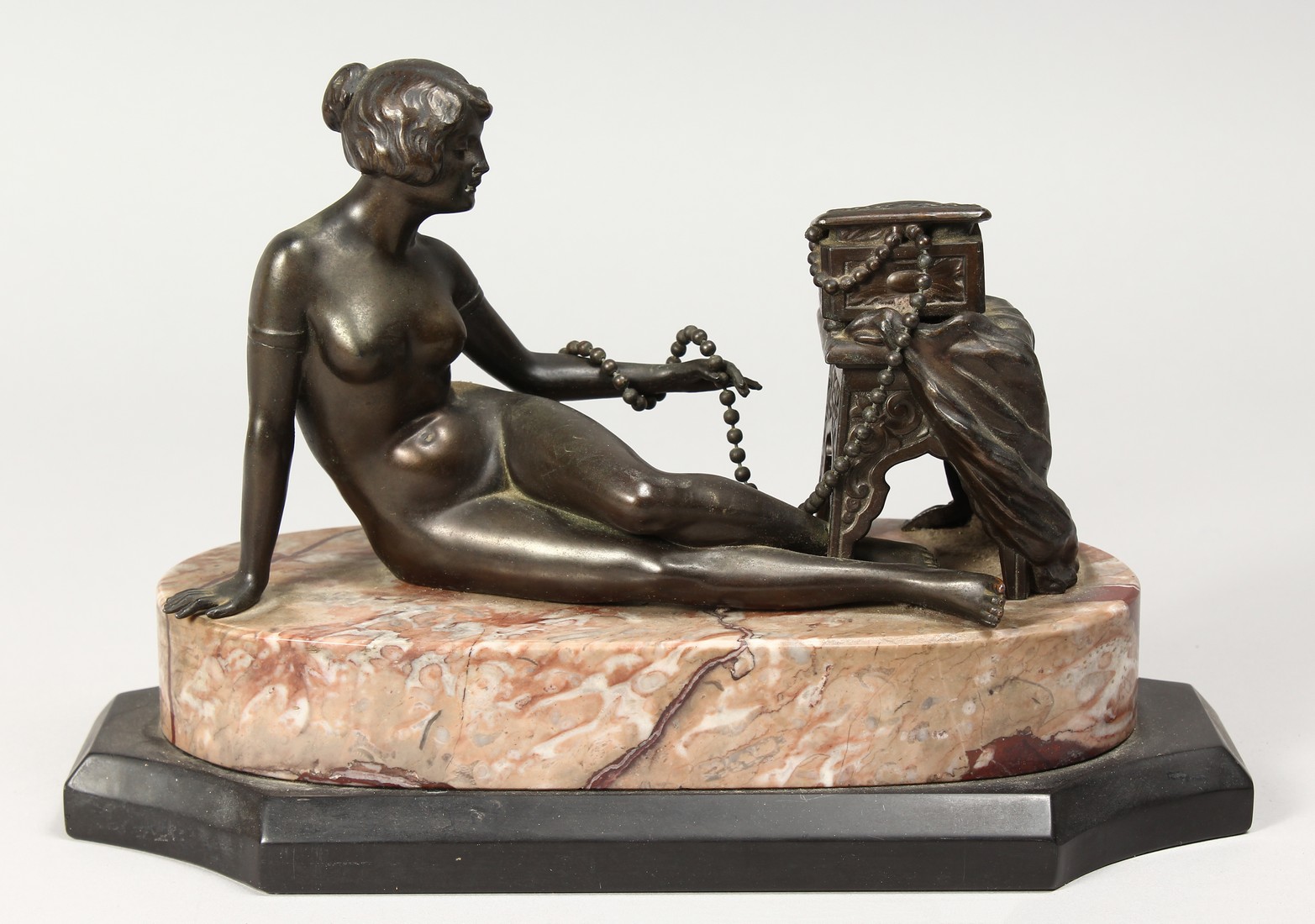 A BRONZE DECO NUDE on a marble base. 10ins long.