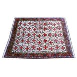 A PERSIAN CARPET, cream ground with stylised red ground medallions. 8ft 2ins x 6ft 6ins.