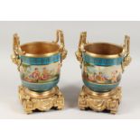 A PAIR OF PORCELAIN AND ORMOLU TWO-HANDLED JARDINIERES with blue ground and painted with a