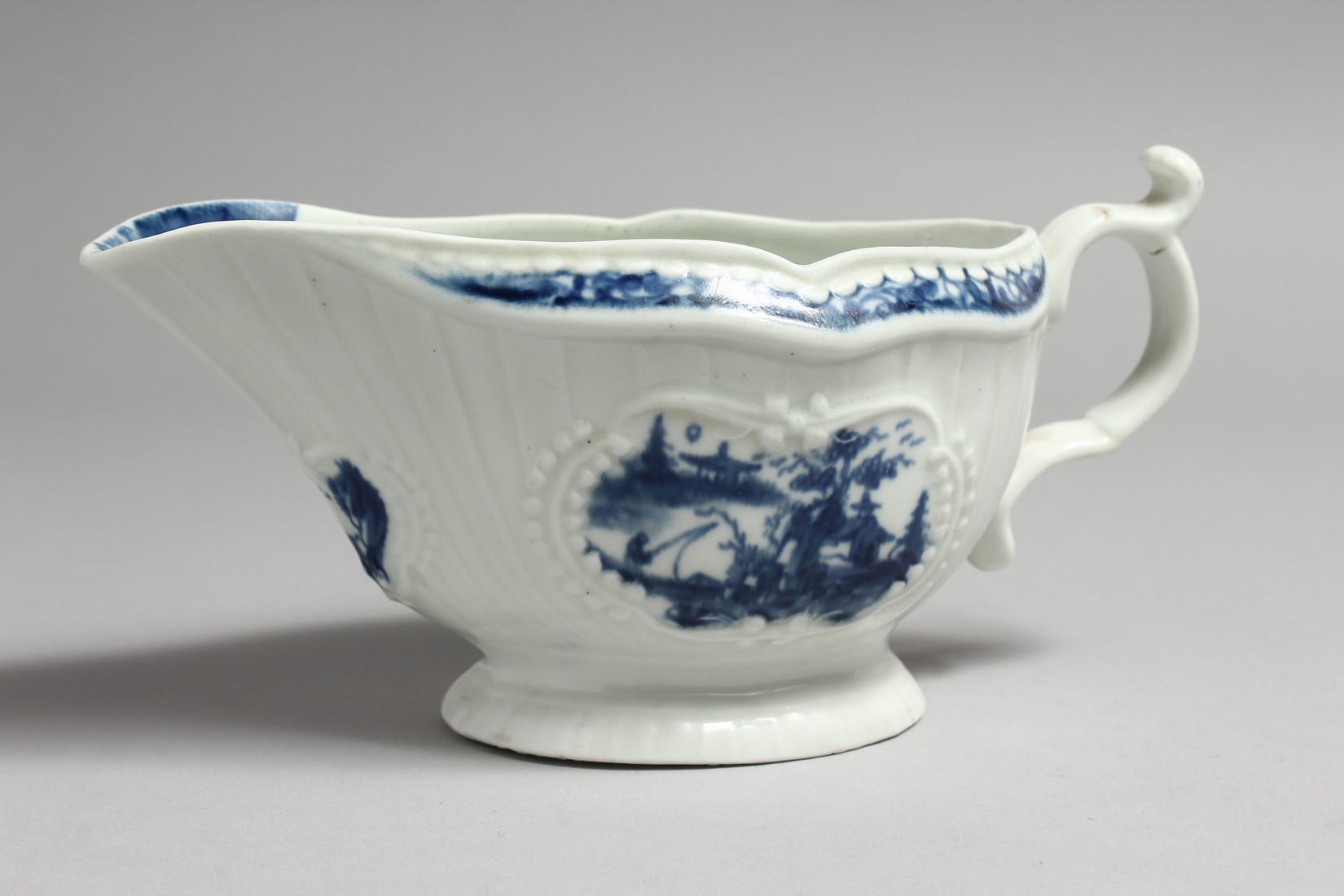 AN 18TH CENTURY WORCESTER SAUCEBOAT, with strap moulded body painted with Chinoiserie landscapes - Image 5 of 11