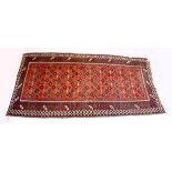 A PERSIAN TEKKE DESIGN RUG, red ground with geometric stylised design. 7ft 10ins x 4ft 2ins.