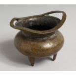 A CHINESE BRONZE TWO-HANDLED CENSER on three legs. Sixteen-character mark. 3.75ins diameter.