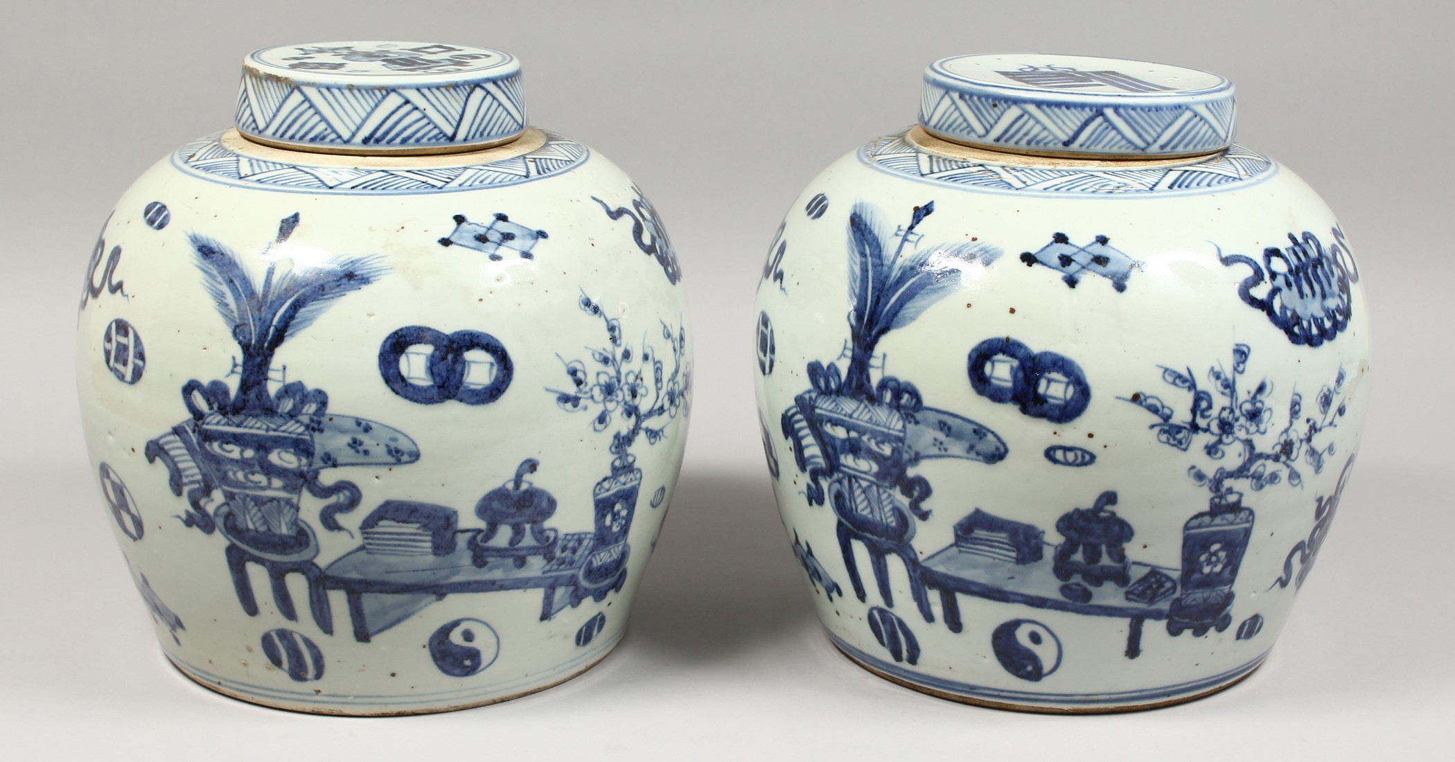 A PAIR OF CHINESE BLUE AND WHITE GINGER JARS AND COVERS. 11ins high.