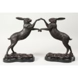 A PAIR OF BRONZE BOXING HARES on shaped marble bases. 11.5ins high.