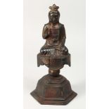 A BRONZE FIGURE OF BUDDHA on a pedestal, one open palm facing forward. 11ins high.