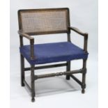 A BEECH FRAMED BOBBIN TURNED ARMCHAIR, with cane work back and upholstered seat.
