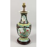 A CHINESE PORCELAIN LAMP with panels of flowers and birds on a wooden base. 19ins high.