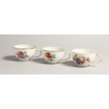 THREE 19TH CENTURY BERLIN CUPS painted with flowers. Sceptre mark in blue.