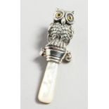 A SILVER AND MOTHER-OF-PEARL OWL RATTLE.