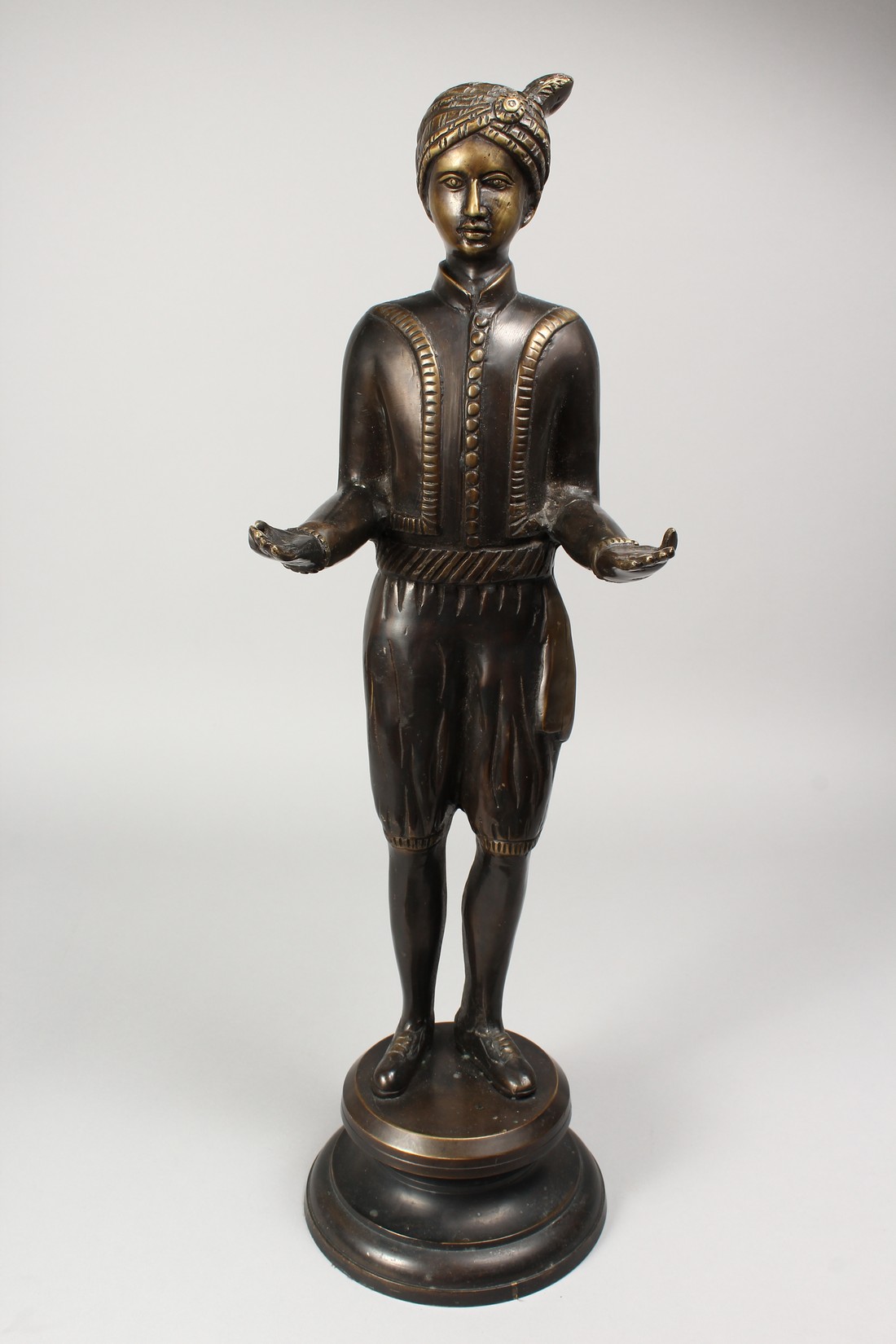 A CAST BRONZE FIGURE OF A STANDING MALE, his arms outstretched, holding a tray, on a circular - Image 2 of 4