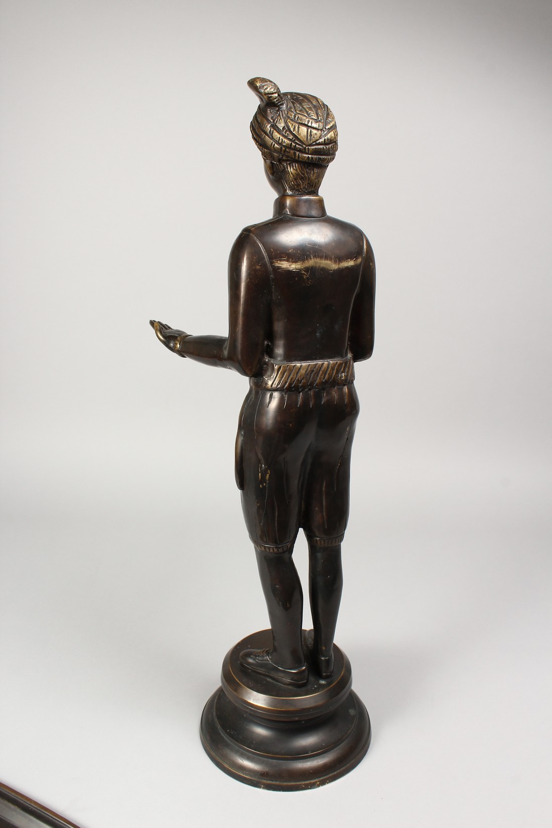 A CAST BRONZE FIGURE OF A STANDING MALE, his arms outstretched, holding a tray, on a circular - Image 4 of 4