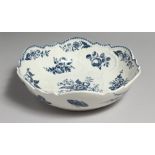 AN 18TH CENTURY WORCESTER JUNKET DISH OR SALAD BOWL, decorated with fruit, vegetables, moths, a