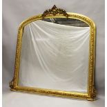 A LARGE GILTWOOD OVERMANTLE MIRROR with domed top, shell and flowers. 5ft 2ins high x 5ft wide.