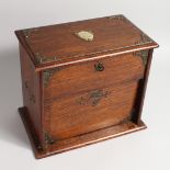 AN OAK SEWING BOX, attributed to Margaret Mary Purcell, the top with brass shield plaque and folding