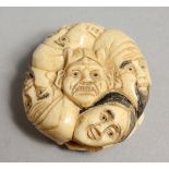 A JAPANESE CARVED BONE FACES NETSUKE. 1.5ins.