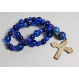 A ROMAN CAST IRON CROSS on a blue bead necklace.