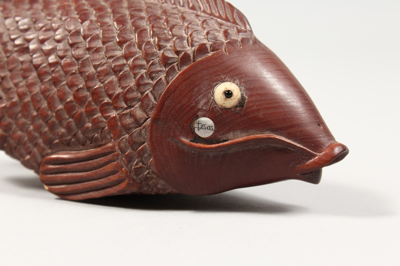 AN UNUSUAL CARVED WOOD CARP with a magnifying glass and compass. 5ins long. - Image 2 of 4
