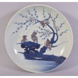 A CHINESE BLUE, WHITE AND IRON RED PORCELAIN DISH, the centre painted with stylised birds on a