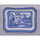 A CHINESE BLUE AND WHITE RECTANGULAR PORCELAIN DISH, the centre painted with a landscape setting,