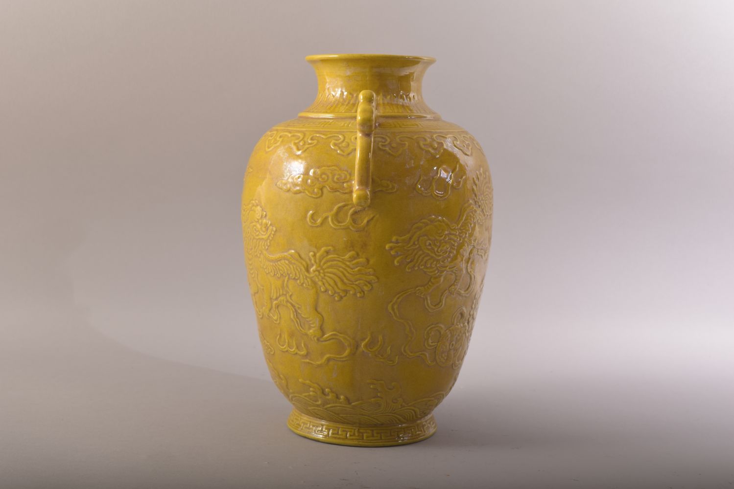 A CHINESE YELLOW GLAZED PORCELAIN TWIN HANDLE JAR - decorated in relief with two lion dogs amongst - Image 2 of 7