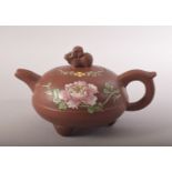 A CHINESE FAMILLE ROSE YIXING CLAY TEAPOT - with poly chrome floral decoration - the cover with a