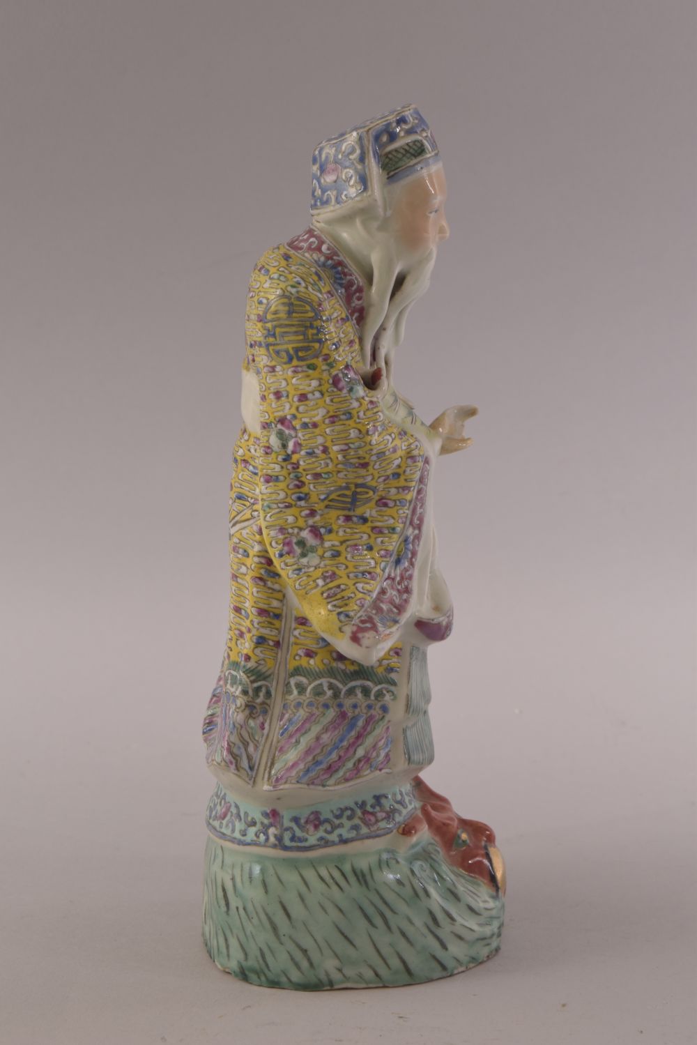 A CHINESE FAMILLE ROSE PORCELAIN FIGURE OF A SAGE, stood upon a wave formation with a mask of a - Image 4 of 8