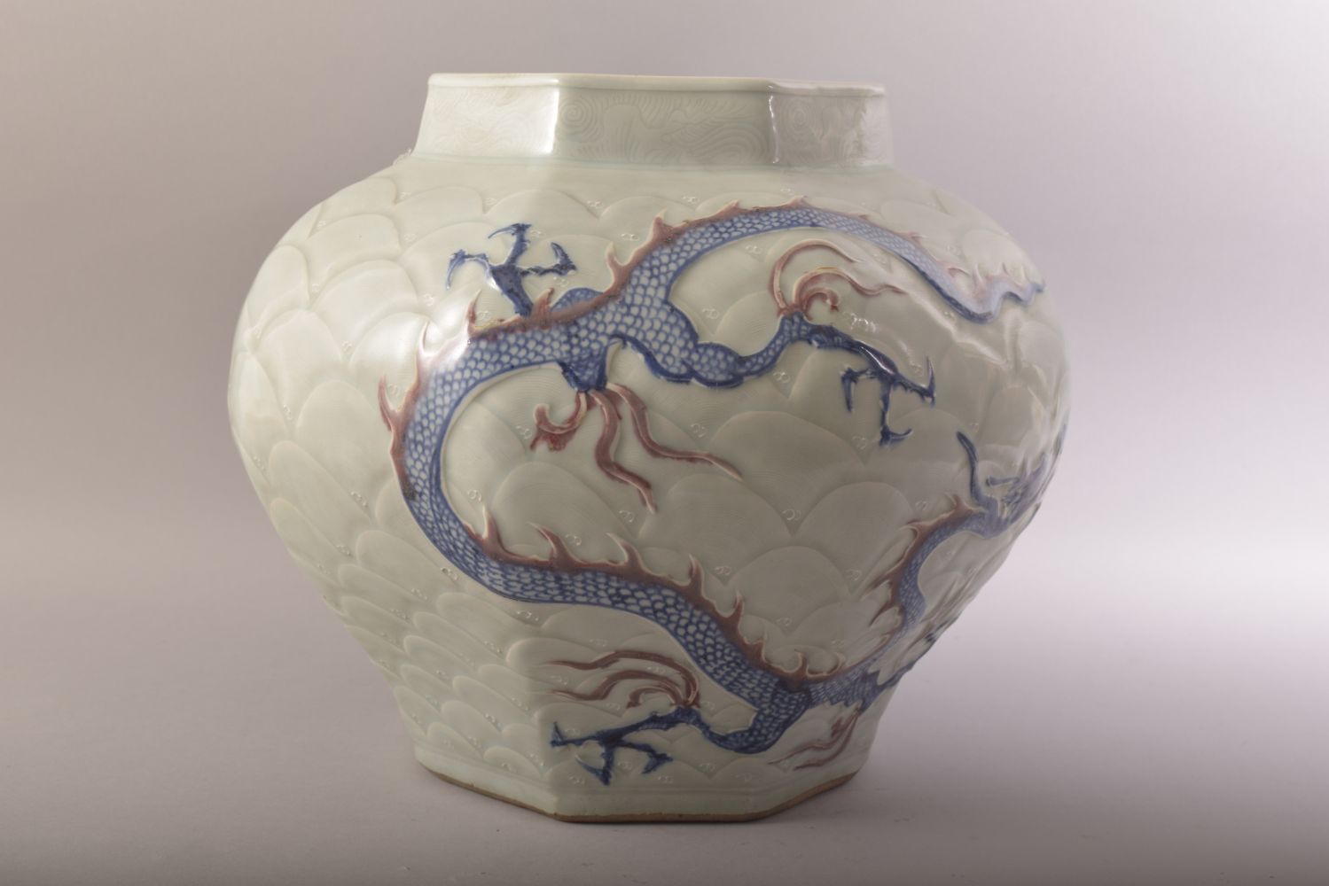 A CHINESE MING STYLE CELADON & IRON RED CARVED PORCELAIN JAR - decorated with scenes of dragons upon - Image 3 of 6