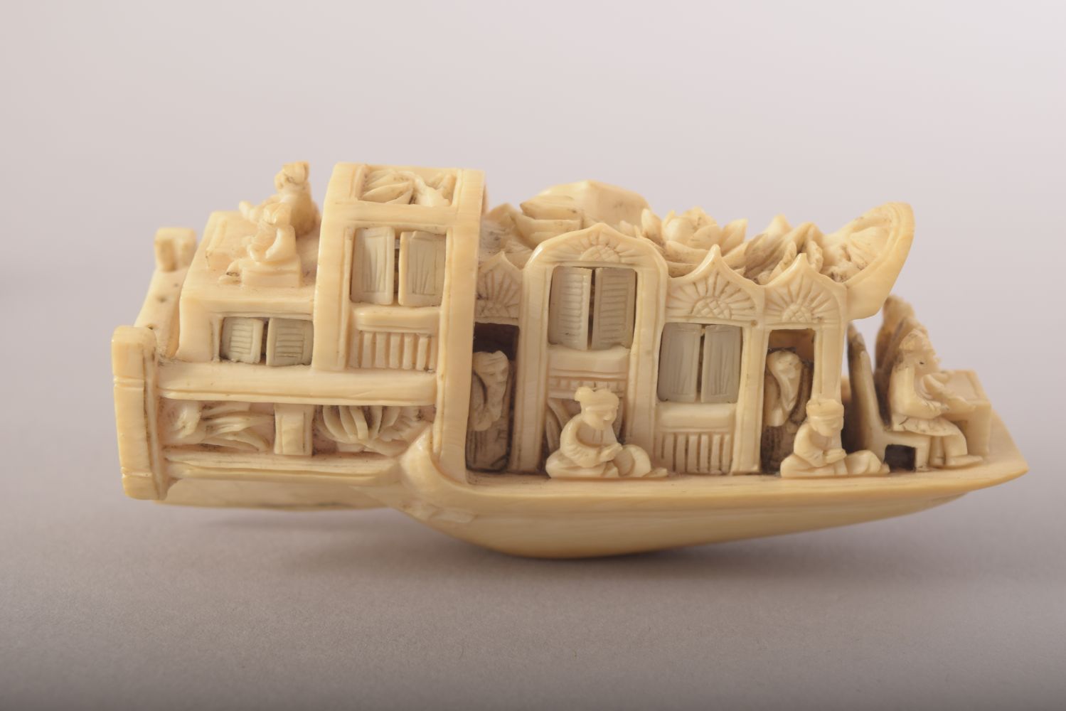 A SMALL CARVED IVORY MODEL OF A JUNK and wooden stand, 8cm long. - Image 2 of 8