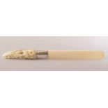 A CARVED IVORY LETTER OPENER, the handle carved with bats, the blade with metal mount, 37cm long.