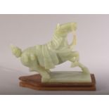 A CHINESE CARVED JADE MODEL OF A HORSE, with a wooden stand, figure 20cm long.