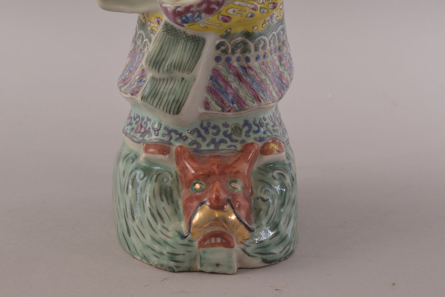 A CHINESE FAMILLE ROSE PORCELAIN FIGURE OF A SAGE, stood upon a wave formation with a mask of a - Image 7 of 8