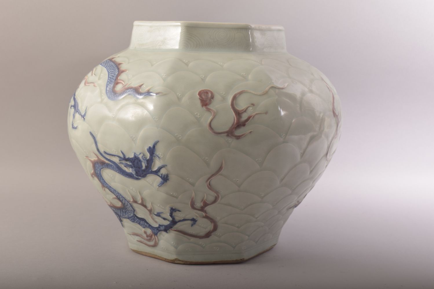 A CHINESE MING STYLE CELADON & IRON RED CARVED PORCELAIN JAR - decorated with scenes of dragons upon - Image 4 of 6