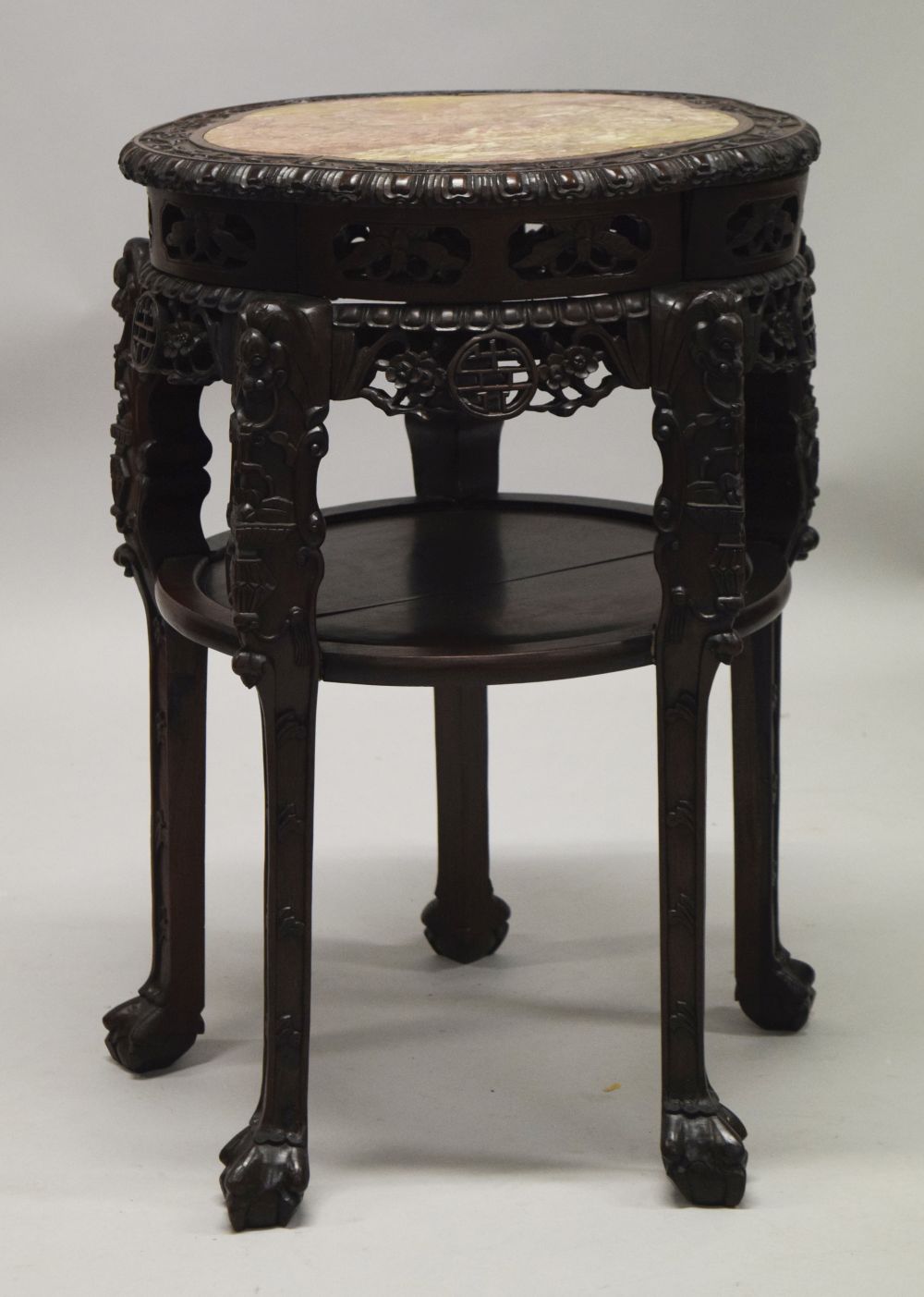 A LARGE AND IMPRESSIVE CHINESE HARDWOOD MARBLE TOP URN STAND, the frieze carved and pierced with