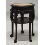 A LARGE AND IMPRESSIVE CHINESE HARDWOOD MARBLE TOP URN STAND, the frieze carved and pierced with