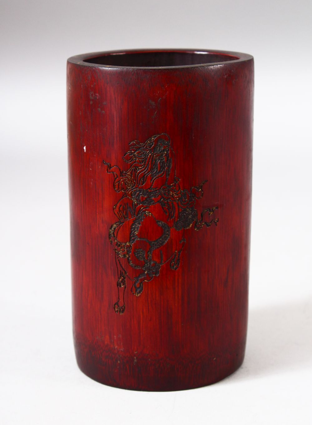 A CHINESE BAMBOO BRUSH POT, with incised decoration depicting a sage / deity and calligraphy, 14cm