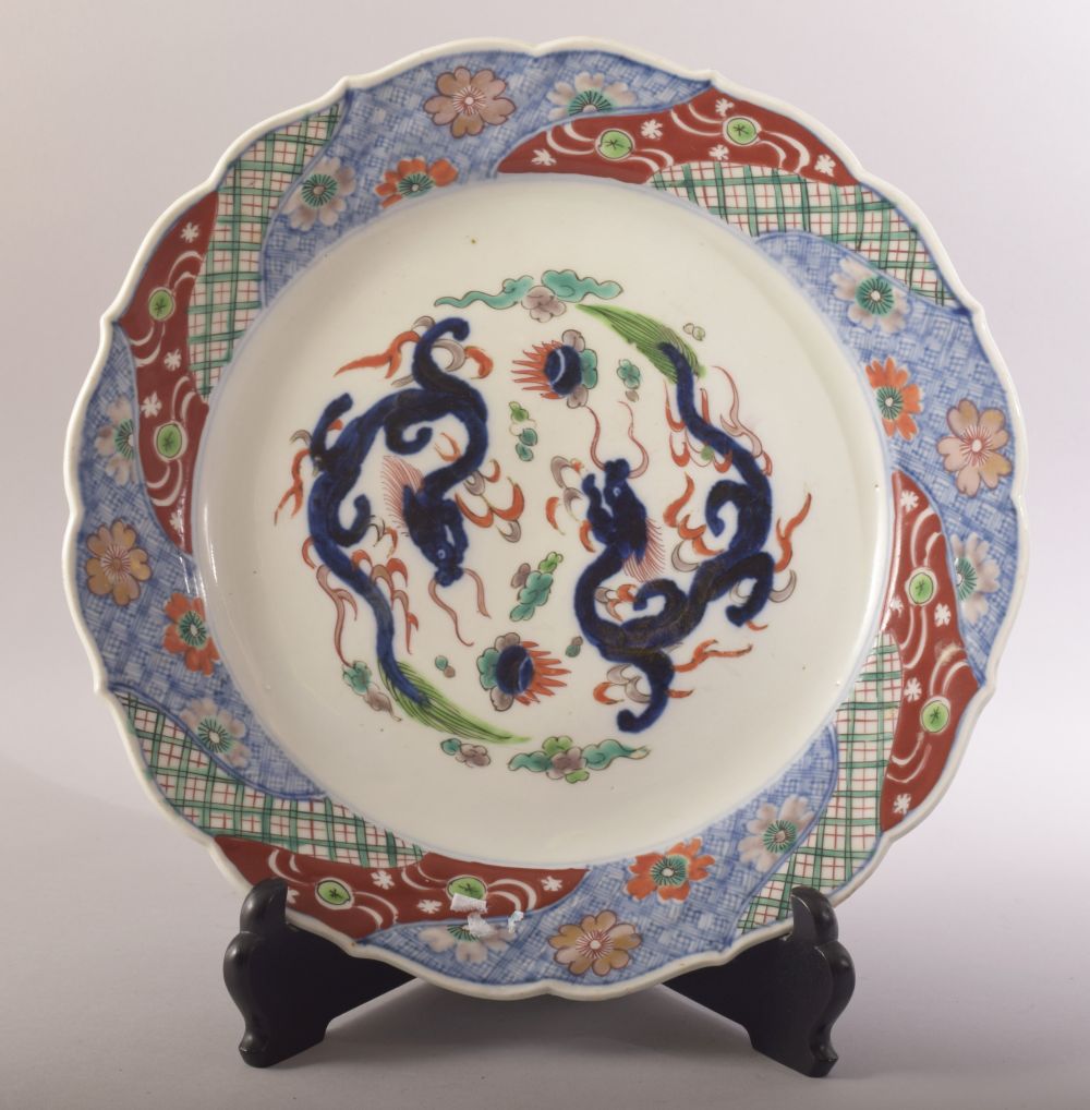 A LARGE JAPANESE PORCELAIN DISH AND STAND, decorated in the imari palette and with dragons to