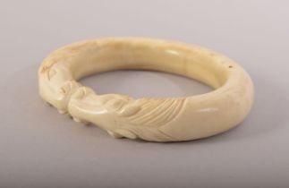 A CARVED BONE BANGLE with horses, 9.5cm x 8cm.