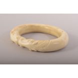A CARVED BONE BANGLE with horses, 9.5cm x 8cm.